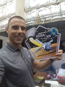 man holding poster for shuttle HERA XIV