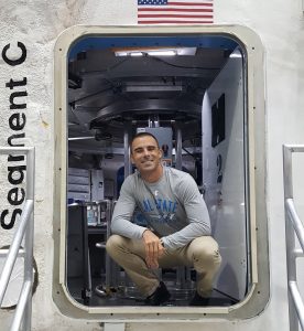 man squatting in shuttle doorway