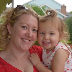 woman smiling holding young daughter