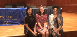 group of 3 posing in front of psi chi table